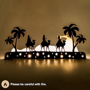 Christmas decoration - three wise kings laser cut. This is the scene where the three wise men bring gifts to the baby Jesus. The decoration was photographed in the dark with lighting inside the decoration. Please be careful with fire.