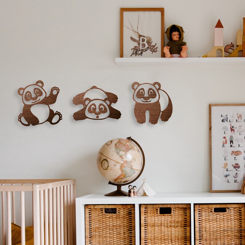 Pandas wall art hang above the dresser and baby crib in the baby's room. Laser cut pandas wall art featuring three fun pandas are made of wood.