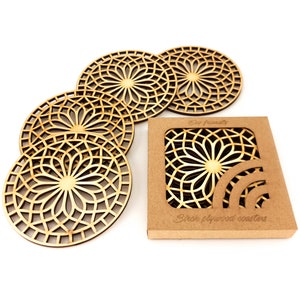 A set of wooden laser-cut coasters in a cardboard box. Placemats are cut out with modern flower motifs. The set includes 4 round drink coasters.