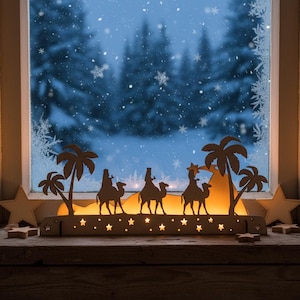 Wooden Christmas decoration 3 kings placed on the windowsill. Candles are lit inside the decoration. The decoration is made of natural wood. Unvarnished.