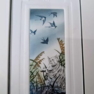 May include: A framed print of a white cat looking up at a flock of blue birds flying in a blue sky. The print is titled "14/150 country glimpses" and signed "Sybil Pitt".