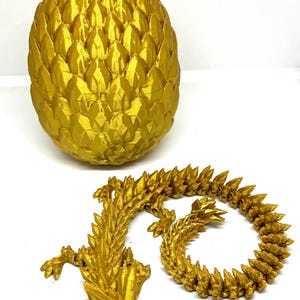 May include: A gold dragon egg with a dragon figurine, both made of 3D printed plastic.