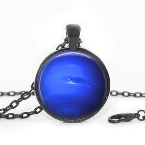 May include: A black chain necklace with a round pendant featuring a blue image of the planet Jupiter.