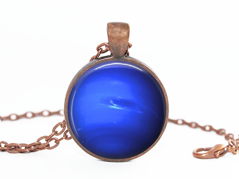 May include: A copper chain necklace with a round pendant featuring a blue, swirling, abstract design.