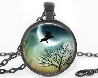 May include: Round pendant necklace with a black chain. The pendant features a silhouetted raven flying in front of a crescent moon and a bare tree against a blue and green background.