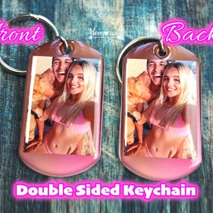 May include: Double-sided keychain with a photo of a couple on each side. The keychain is silver with a pink and brown gradient background. The couple is smiling and wearing swimwear. The text "Front" and "Back" are written in pink on the top of the keychain.
