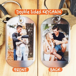 May include: Double sided keychain with a photo of a couple on each side. The front side shows the couple hugging in a park. The back side shows the couple sitting on a bench.
