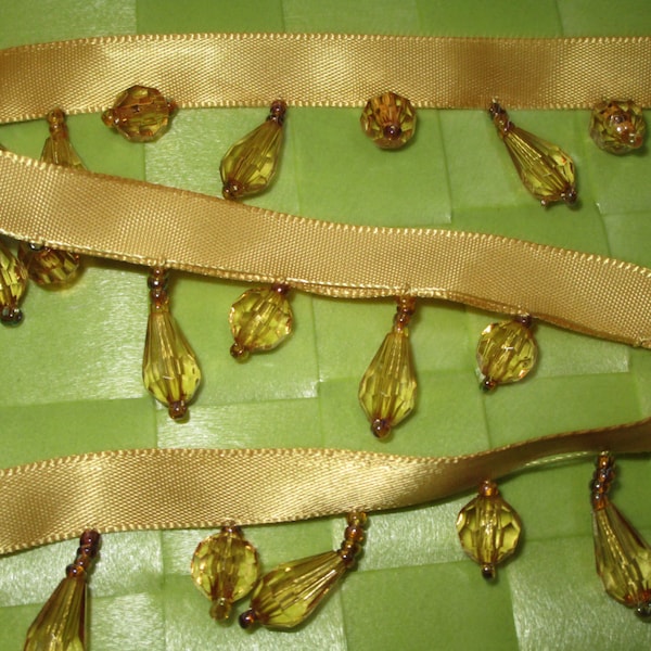 this is a 5/8 yard in 1 1/4" width in gold ribbon and mine gold color bead fringe satin ribbon trim for your fashion design sewing project.