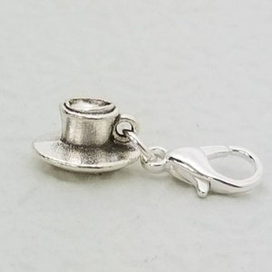 Könnte beinhalten: Silberner Anhänger in Form einer Kaffeetasse und Untertasse mit einem silbernen Karabinerverschluss.