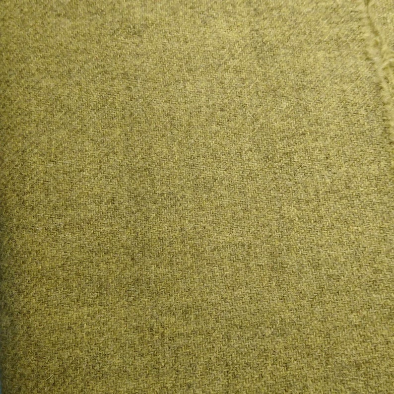 May include: A close-up of a textured fabric in a muted olive green color.