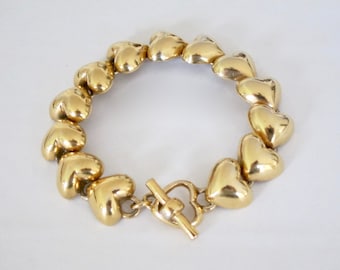 1980, articulated bracelet with gold metal heart links. Unsigned.