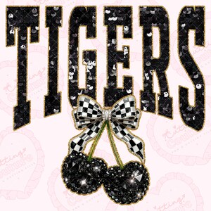 May include: A graphic design featuring the word "TIGERS" in black sequined letters with gold trim. Below the word is a checkered bow and two black jeweled cherries. The background is light pink.