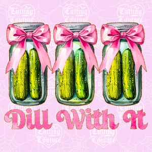 K&ouml;nnte beinhalten: Drei Gl&auml;ser mit Gurken, jedes mit einer rosa Schleife. Die Gl&auml;ser tragen die Aufschrift "Dill With It" in rosa Schrift mit goldenen Glitzerakzenten. Der Hintergrund ist hellrosa.