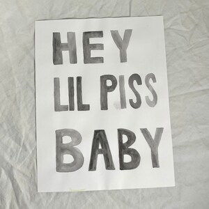May include: Black and white watercolor painting on paper with the text "HEY LIL PISS BABY".