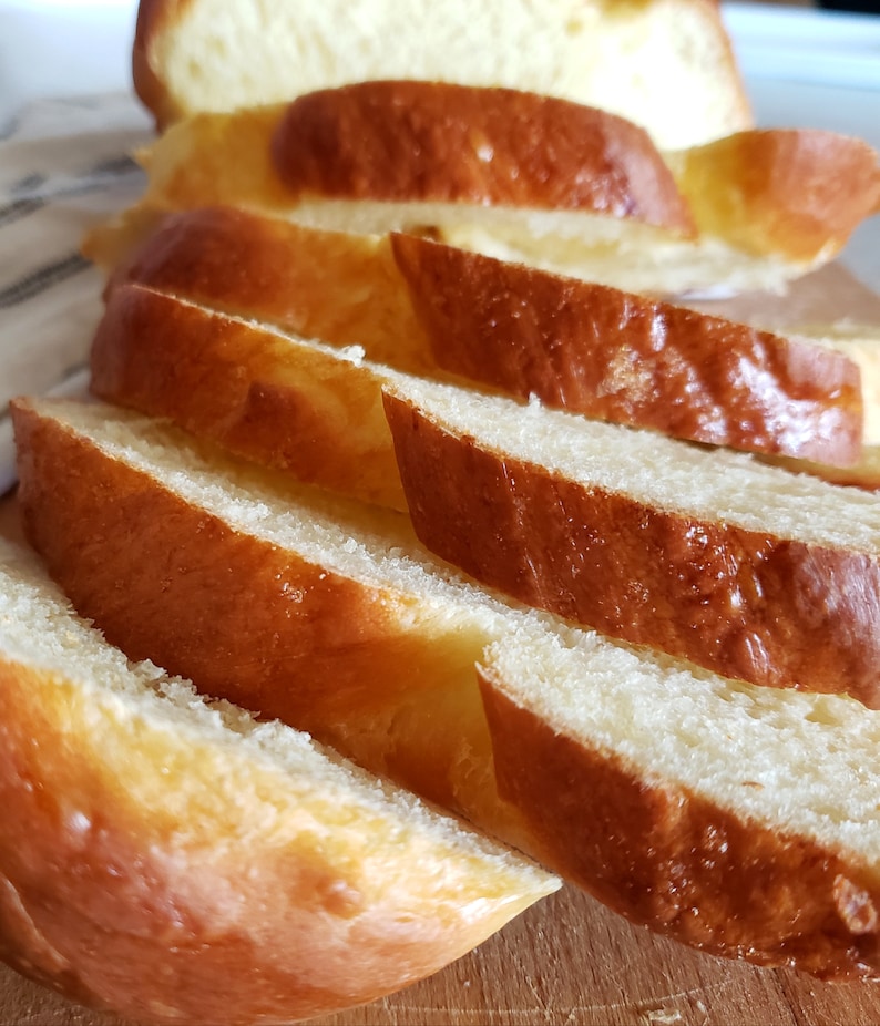 Puede incluir: Primer plano de una hogaza de pan rebanado. El pan es de color marr&oacute;n dorado y tiene una textura suave y esponjosa.
