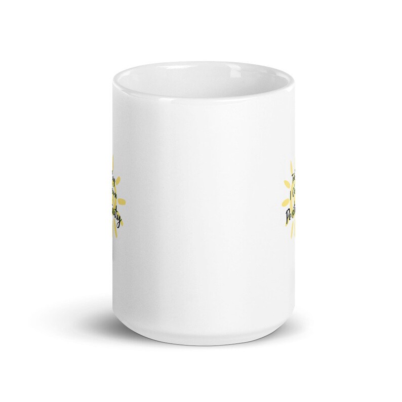 May include: White ceramic mug with a yellow sun graphic and the text "The sun is always shining" on one side and "Positively" on the other side.
