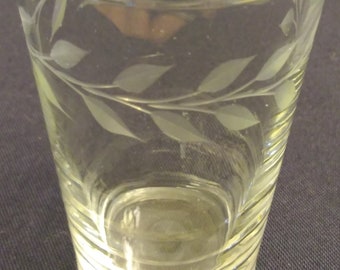 vintage juice glass with leaf etching around the top.