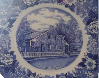 Può includere: Piatto in ceramica blu e bianco con bordo floreale e un'immagine del quartier generale del generale Lee a Gettysburg, Pennsylvania.