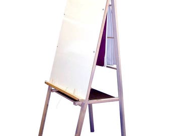 May include: A wooden easel with a white dry erase board and a shelf below. The easel is made of natural wood and has a simple design.