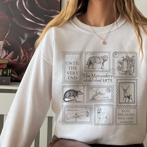 Bluza z kolekcji znaczków Marauders * Pocztówka z odzieżą czarodzieja James Moony Remus Syriusz ATYD * Książka Fandom Merch Prezent dla czytelnika strona 394