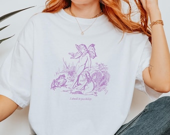 May include: White t-shirt with a purple graphic of a fairy and the text "I dwell in possibility".
