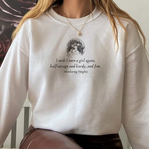 May include: White sweatshirt with a black graphic print of a woman in a circle with the text "I wish I were a girl again, half-savage and hardy, and free. -Wuthering Heights"
