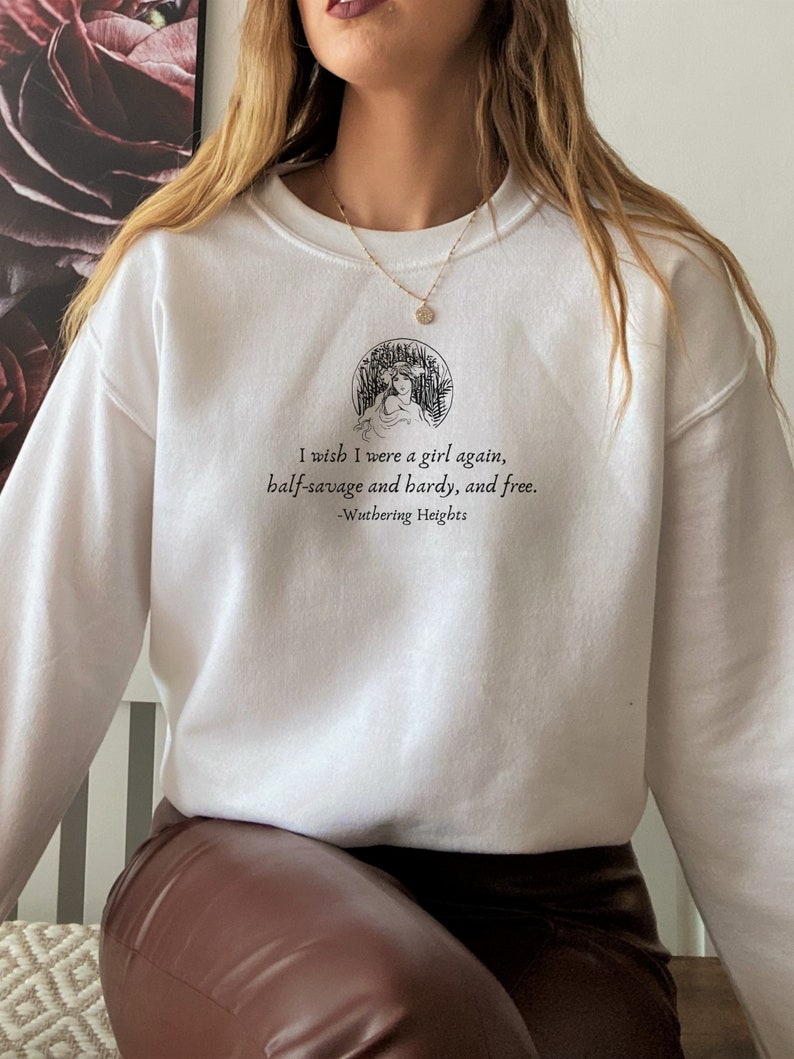 May include: White sweatshirt with a black graphic print of a woman in a circle with the text "I wish I were a girl again, half-savage and hardy, and free. -Wuthering Heights"