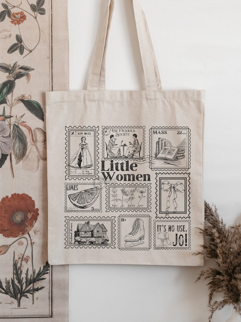 May include: A beige tote bag with a black and white design featuring vintage postage stamps with illustrations of women, a house, a lemon, a pair of ice skates, a bow, and a book. The text "Little Women" is printed in black on the bag.