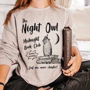 May include: Gray sweatshirt with a black graphic of an owl reading a book. The text on the sweatshirt reads "The Night Owl Midnight Book Club meets weekly Just one more chapter!"