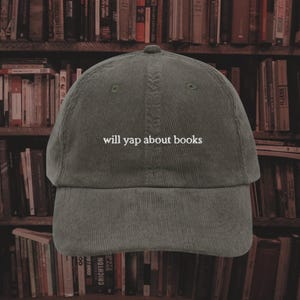 May include: A green corduroy baseball cap with the text "will yap about books" embroidered in white on the front.