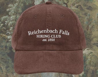 May include: A brown corduroy baseball cap with the text "Reichenbach Falls HIKING CLUB est. 1891" in white. The cap has a curved brim and a top button. The background is a landscape painting.