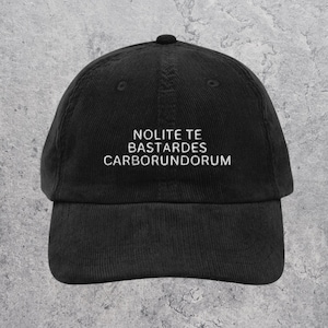 May include: Black corduroy baseball cap with white embroidered text that reads "NOLITE TE BASTARDES CARBORUNDORUM".