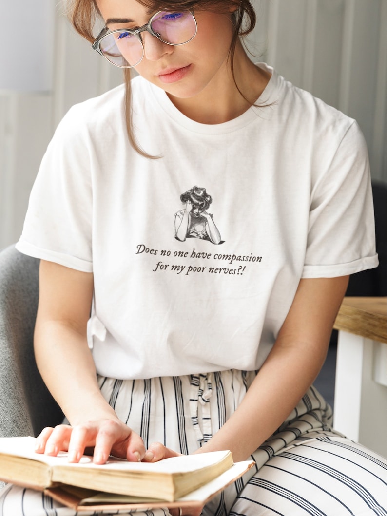 K&ouml;nnte beinhalten: Wei&szlig;es T-Shirt mit einer Schwarzwei&szlig;illustration einer Frau mit dem Text "Does no one have compassion for my poor nerves?!"