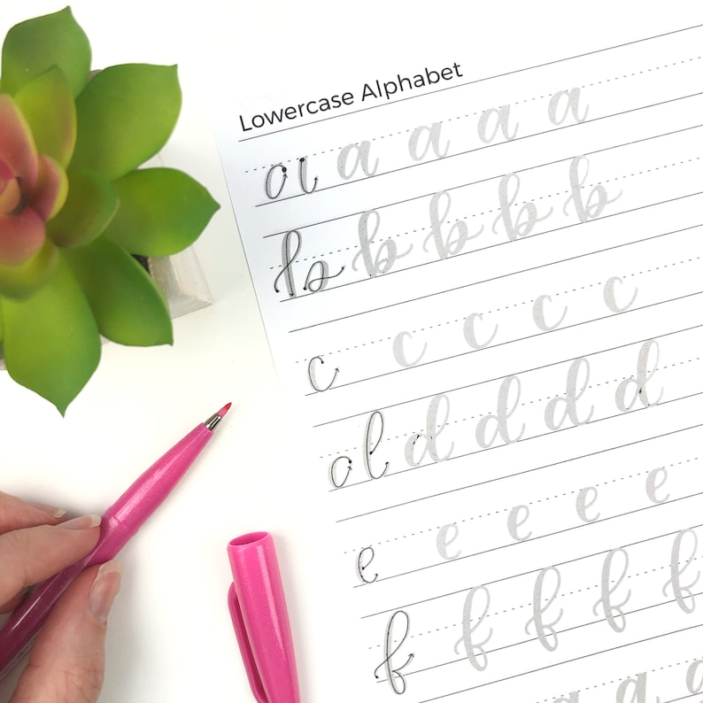 Peut inclure: Une feuille d'exercices d'alphabet minuscule avec des lignes grises et des lettres grises. Les lettres sont &eacute;crites en cursive. La feuille est sur une surface blanche.