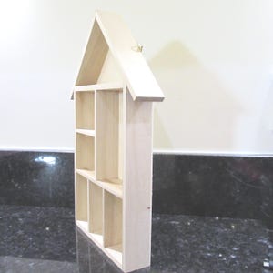 Wooden House Shaped Display Shelves Unit Suitable to display Small Ornaments, Dolls House Miniatures, Thimbles, Lego Figures The unit measures 30cm High x 22cm Wide x 4.5cm Deep Can be Free-Standing or Wall Mounted. Supplied with two hanging hooks.