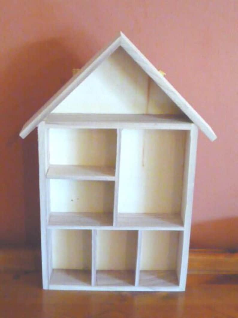 Wooden House Shaped Display Shelves Unit Suitable to display Small Ornaments, Dolls House Miniatures, Thimbles, Lego Figures The unit measures 30cm High x 22cm Wide x 4.5cm Deep Can be Free-Standing or Wall Mounted. Supplied with two hanging hooks.