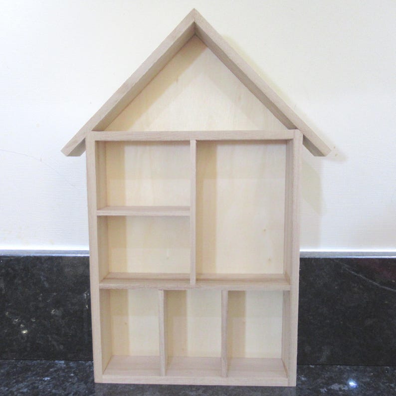 Wooden House Shaped Display Shelves Unit Suitable to display Small Ornaments, Dolls House Miniatures, Thimbles, Lego Figures The unit measures 30cm High x 22cm Wide x 4.5cm Deep Can be Free-Standing or Wall Mounted. Supplied with two hanging hooks.