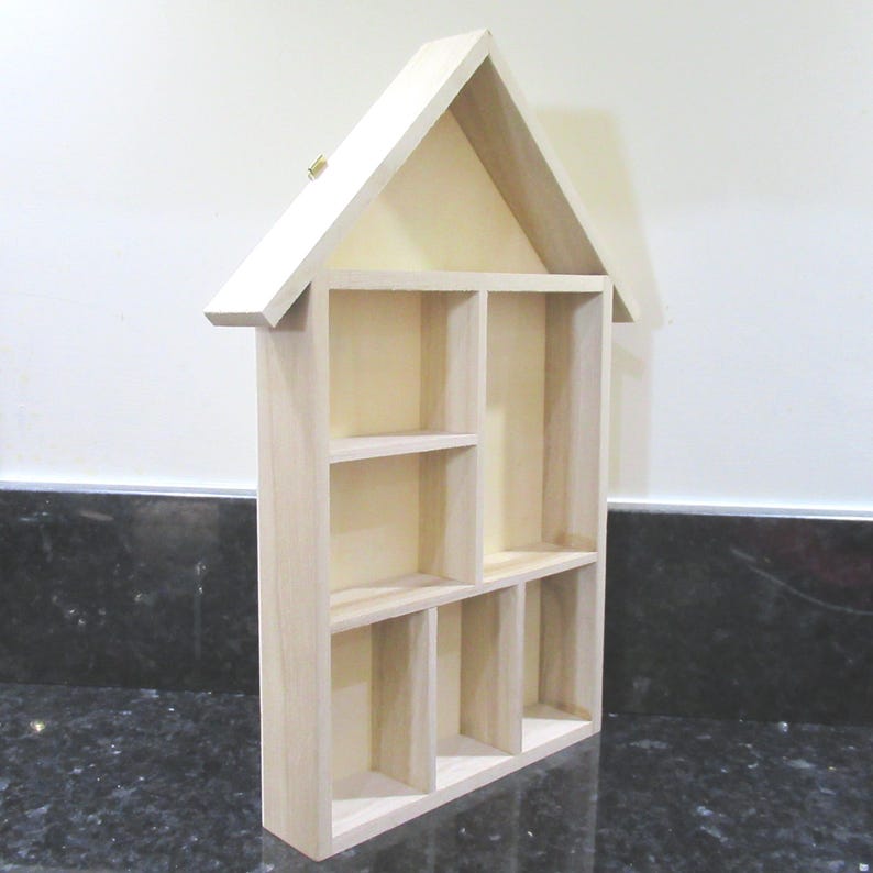 Wooden House Shaped Display Shelves Unit Suitable to display Small Ornaments, Dolls House Miniatures, Thimbles, Lego Figures The unit measures 30cm High x 22cm Wide x 4.5cm Deep Can be Free-Standing or Wall Mounted. Supplied with two hanging hooks.
