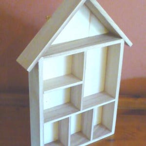 Wooden House Shaped Display Shelves Unit Suitable to display Small Ornaments, Dolls House Miniatures, Thimbles, Lego Figures The unit measures 30cm High x 22cm Wide x 4.5cm Deep Can be Free-Standing or Wall Mounted. Supplied with two hanging hooks.