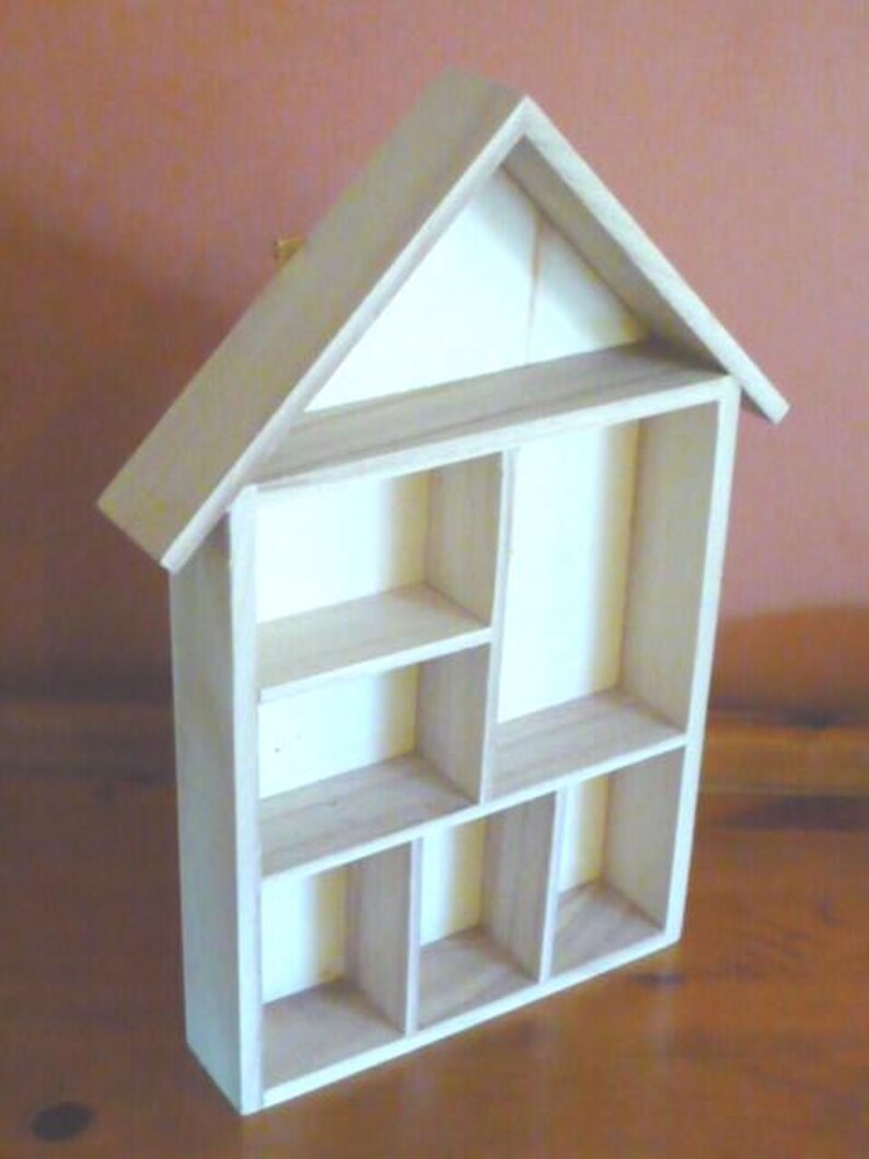 Wooden House Shaped Display Shelves Unit Suitable to display Small Ornaments, Dolls House Miniatures, Thimbles, Lego Figures The unit measures 30cm High x 22cm Wide x 4.5cm Deep Can be Free-Standing or Wall Mounted. Supplied with two hanging hooks.