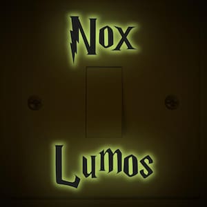 May include: A light switch with glow-in-the-dark stickers that say "Nox" and "Lumos" in a stylized font.