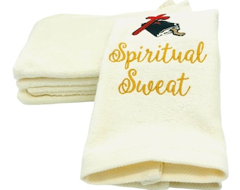 May include: A stack of white towels with an embroidered design. The design features a red cross and a book with the words "Spiritual Sweat" in gold lettering.