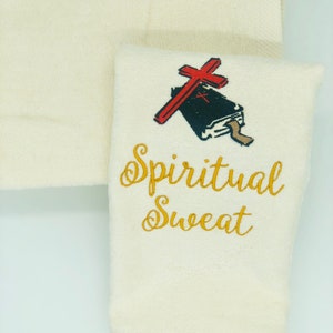 May include: White hand towel with gold embroidery that reads "Spiritual Sweat". A red cross with a black bible is embroidered above the text.