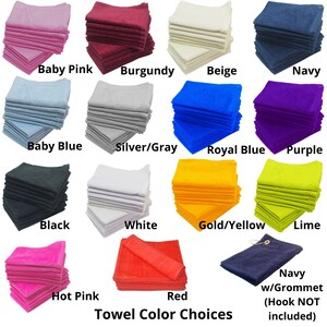 May include: A selection of 15 different colors of towels, including baby pink, burgundy, beige, navy, baby blue, silver/gray, royal blue, purple, black, white, gold/yellow, lime, hot pink, red, and navy with a grommet. The text "Towel Color Choices" is printed below the towels. The text "Navy w/Grommet (Hook NOT included)" is printed below the navy towel with a grommet.