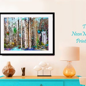 May include: A framed abstract painting of a forest with birch trees, colorful foliage, and a blue bird. The painting has a white background and a black frame. The painting is hanging on a white wall above a blue dresser.