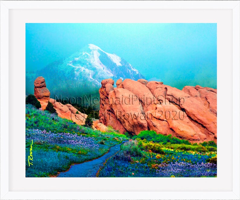 May include: A colourful landscape painting depicting a mountain range with snow-capped peaks, red rock formations, and a winding path through a field of purple wildflowers. The painting is signed "T. Rowan 2020" in the bottom left corner.