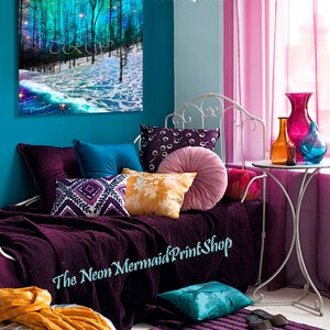 May include: A purple and teal bedroom with a white metal bed frame, a purple and teal throw blanket, and a variety of pillows. The bed is decorated with a painting of a moonlit forest scene with the text "Svaha 2020 (C) Teri Rowan" on the wall. The text "The Neon Mermaid Print Shop" is visible on the bedspread.