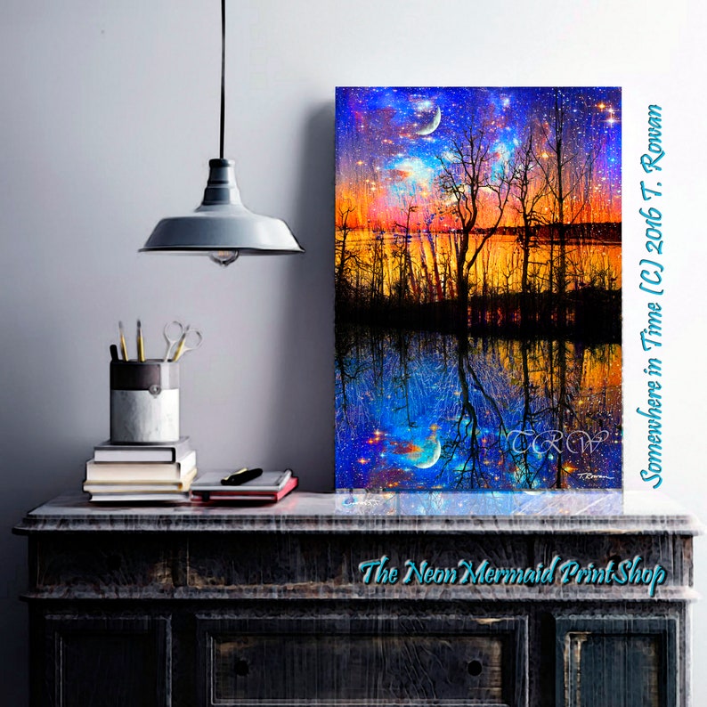May include: A digital painting of a starry night sky reflected in a still body of water. The sky is a vibrant blue with streaks of orange and yellow. The water is a deep blue with a reflection of the sky and trees. The trees are silhouetted against the sky and water. The painting is titled "Somewhere in Time (C) 2016 T. Rowan".