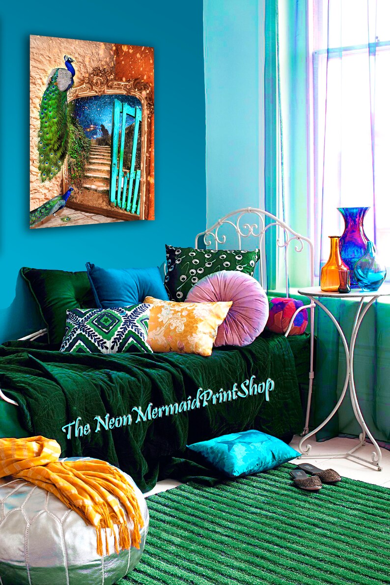 May include: A colourful interior with a peacock art print, emerald green bedding, and assorted cushions. A silver ottoman with a yellow throw and a green rug contribute to the room's eclectic style. The text "The Neon Mermaid Print Shop" is visible.