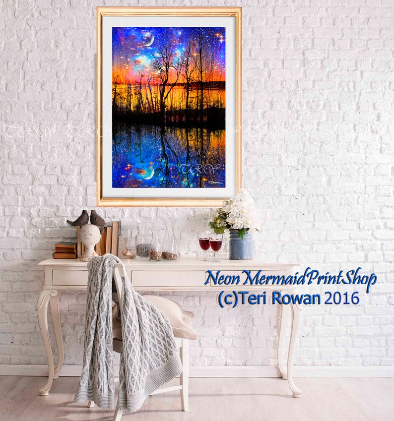May include: A framed print of a colorful landscape with a lake, trees, and a starry sky. The reflection of the scene is visible in the water. The print is titled "Neon Mermaid Print Shop (c) Teri Rowan 2016".